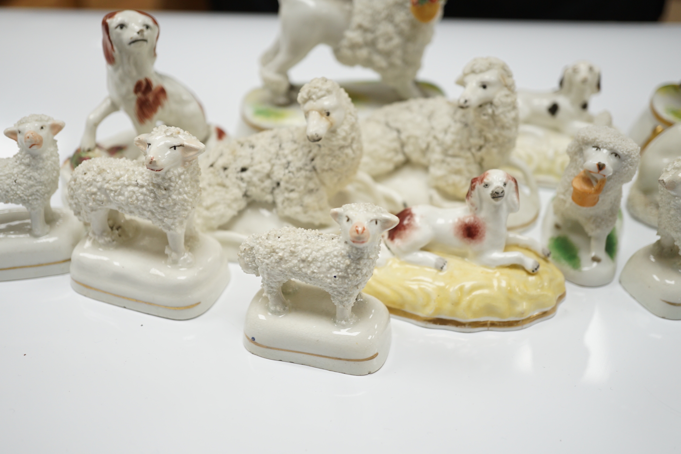 Two Samuel Alcock models of recumbent spaniels, a Staffordshire porcelain model of a seated spaniel and six similar sheep c.1830-50, and five Continental porcelain models of poodles (11)